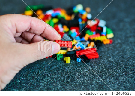 Hand Holding Bricks - Creative Play Concept Hand Holding Bricks - Creative Play Concept 142406523