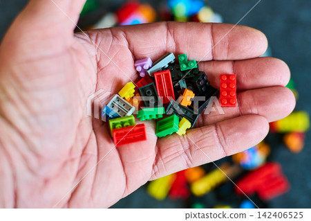 Hand Holding Diverse Bricks - Creative Play Concept Hand Holding Diverse Bricks - Creative Play Concept 142406525