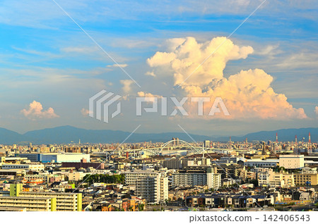 A view from Namihaya Bridge of a giant cumulonimbus cloud bathed in the setting sun, along with Chitose Bridge and the Osaka city skyline. A view from Namihaya Bridge of a giant cumulonimbus cloud bathed in the setting sun, along with Chitose Bridge and the Osaka city skyline. 142406543