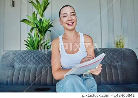 Smiling young woman looking at webcam during online video call Smiling young woman looking at webcam during online video call 142406841