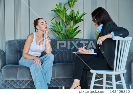 Young woman having consultation with female therapist on sofa Young woman having consultation with female therapist on sofa 142406850