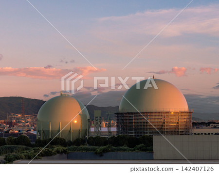 The cityscape bathed in the sunset and the two brothers of the large gas tanks. The cityscape bathed in the sunset and the two brothers of the large gas tanks. 142407126