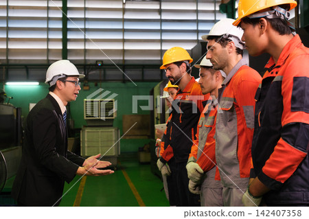The manager gave a training speech to the workers before they started working in the factory. 142407358