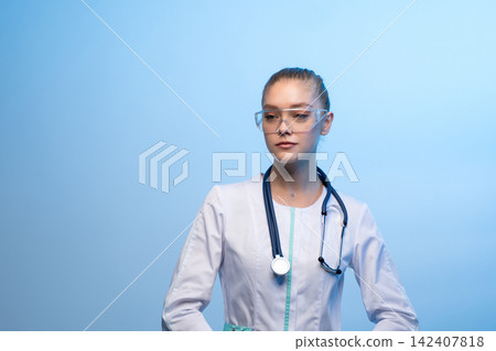Female medical professional wearing protective goggles and stethoscope Female medical professional wearing protective goggles and stethoscope 142407818
