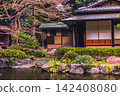 The tea house architecture and stone arrangements by the pond in the Shinchi Garden, bathed in warm light. March 2024. 142408080
