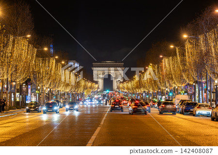 The Champs-Élysées and Arc de Triomphe adorned with Christmas lights during the holiday season. The Champs-Élysées and Arc de Triomphe adorned with Christmas lights during the holiday season. 142408087