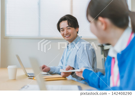A scene of office romance where a male employee receives a love letter with a beaming smile. A scene of office romance where a male employee receives a love letter with a beaming smile. 142408290