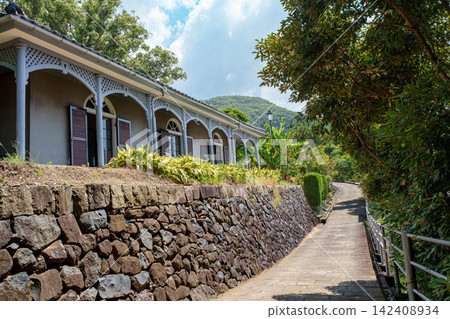 長崎傳統的日式西式融合建築在鬱鬱蔥蔥的花園和蔚藍的天空映襯下格外引人注目。 長崎傳統的日式西式融合建築在鬱鬱蔥蔥的花園和蔚藍的天空映襯下格外引人注目。 142408934