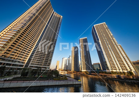 高聳入雲的公寓大樓和城市景觀直插藍天。 高聳入雲的公寓大樓和城市景觀直插藍天。 142409136