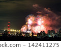 Spectacular colorful fireworks illuminating the night sky above a dense city skyline during a festive celebration. 142411275