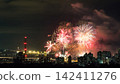 Spectacular colorful fireworks illuminating the night sky above a dense city skyline during a festive celebration. 142411276