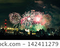 Spectacular colorful fireworks illuminating the night sky above a dense city skyline during a festive celebration. 142411279