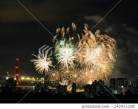 Spectacular colorful fireworks illuminating the night sky above a dense city skyline during a festive celebration. Spectacular colorful fireworks illuminating the night sky above a dense city skyline during a festive celebration. 142411280