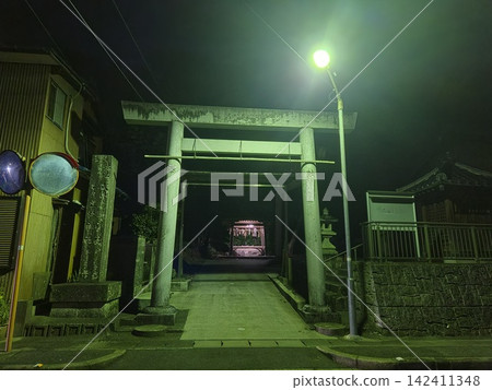 A shrine at night, and a torii gate illuminated by streetlights. A shrine at night, and a torii gate illuminated by streetlights. 142411348