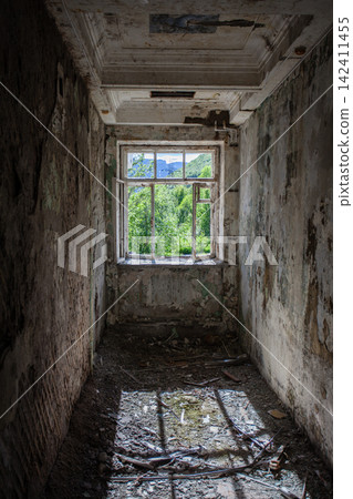 Abandoned Soviet-era Palace of Culture in the former mining settlement of Kukisvumchorr near Kirovsk, Murmansk Region, Russia. The decaying cultural building stands beneath the Khibiny Mountains, surr 142411455