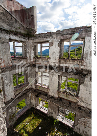 Abandoned Soviet-era Palace of Culture in the former mining settlement of Kukisvumchorr near Kirovsk, Murmansk Region, Russia. The decaying cultural building stands beneath the Khibiny Mountains, surr Abandoned Soviet-era Palace of Culture in the former mining settlement of Kukisvumchorr near Kirovsk, Murmansk Region, Russia. The decaying cultural building stands beneath the Khibiny Mountains, surr 142411467