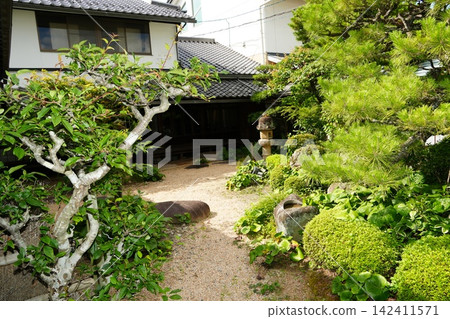 一條穿過日式花園的小徑和一棟白牆建築(寧靜的日間景色) 一條穿過日式花園的小徑和一棟白牆建築(寧靜的日間景色) 142411571
