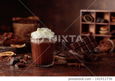 Hot chocolate with whipped cream in a glass mug. Hot chocolate with whipped cream in a glass mug. 142411730