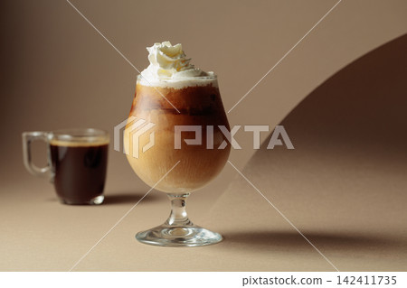 Black coffee and iced coffee cocktail on a beige background. Black coffee and iced coffee cocktail on a beige background. 142411735