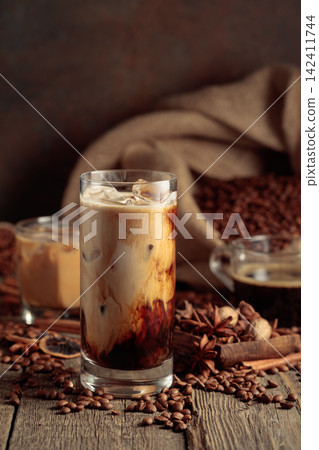 Iced coffee with cream on an old wooden table. Iced coffee with cream on an old wooden table. 142411744