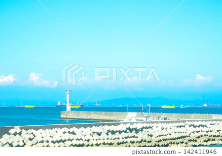 A pier leading to a white lighthouse A pier leading to a white lighthouse 142411946