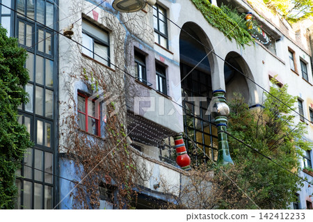 Artistic architecture and mosaic columns of famous Hundertwasser building facade. Artistic architecture and mosaic columns of famous Hundertwasser building facade. 142412233