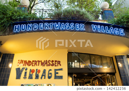 Entrance facade with blue neon sign of Hundertwasser Village shopping center in Vienna Entrance facade with blue neon sign of Hundertwasser Village shopping center in Vienna 142412236