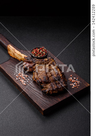 Grilled beef Tomahawk steak seasoned with salt and spices. Tomahawk steak Grilled beef Tomahawk steak seasoned with salt and spices. Tomahawk steak 142412289