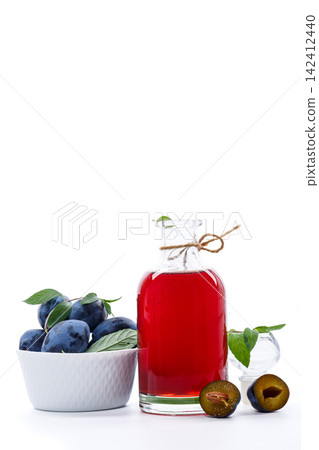 Plum fruit syrup in glass bottle on bright white background 142412440