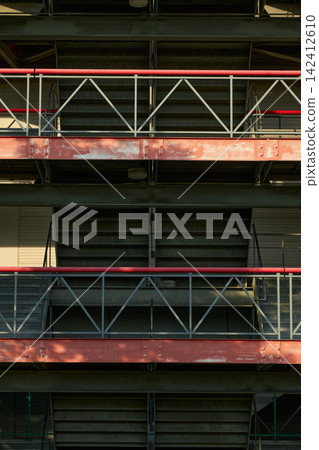 The structural beauty of a multi-story parking garage: the inorganic steel framework and railings are arranged in a regular pattern. The structural beauty of a multi-story parking garage: the inorganic steel framework and railings are arranged in a regular pattern. 142412610