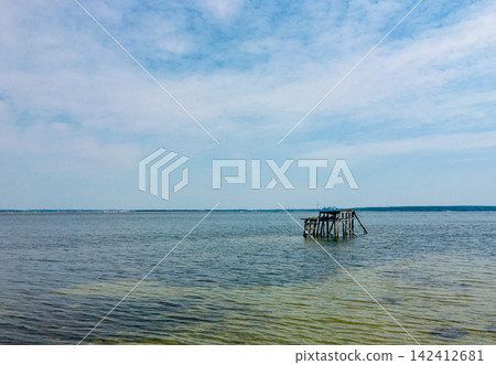 Netishyn Reservoir summer landscapes with wooden pier, green reeds, and beach rest, Ukraine Netishyn Reservoir summer landscapes with wooden pier, green reeds, and beach rest, Ukraine 142412681