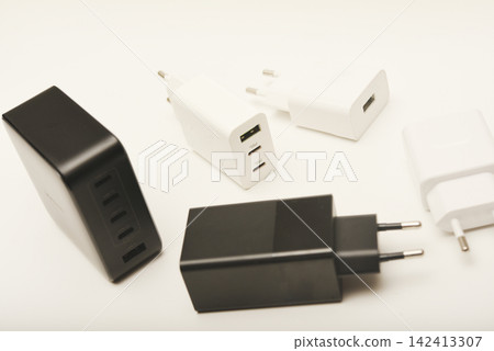 Black and white power supplies for mobile devices. Powerful power supplies on a white background. Charging devices for gadgets. Black and white power supplies for mobile devices. Powerful power supplies on a white background. Charging devices for gadgets. 142413307