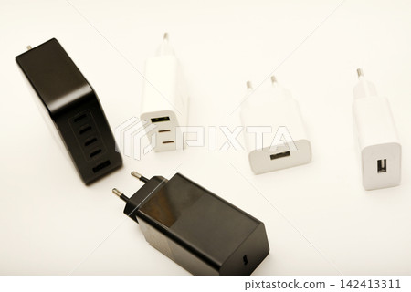 Black and white power supplies for mobile devices. Powerful power supplies on a white background. Charging devices for gadgets. Black and white power supplies for mobile devices. Powerful power supplies on a white background. Charging devices for gadgets. 142413311