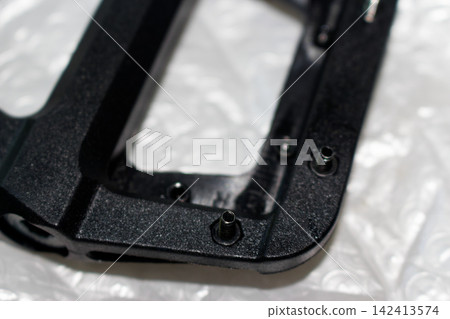 Close-up macro detail of sharp metal traction pins installed on a durable black nylon bicycle pedal, brand new cycling hardware components designed for professional mountain bike riding Close-up macro detail of sharp metal traction pins installed on a durable black nylon bicycle pedal, brand new cycling hardware components designed for professional mountain bike riding 142413574