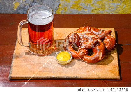 beer pretzel and mustard on a wooden table. rustic oktoberfest drink and food background. grungy wall texture. top view beer pretzel and mustard on a wooden table. rustic oktoberfest drink and food background. grungy wall texture. top view 142413738