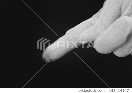 Person in white glove checking cleanliness of black background, closeup Person in white glove checking cleanliness of black background, closeup 142414147