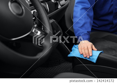 Car wash worker cleaning automobile interior, closeup Car wash worker cleaning automobile interior, closeup 142414172