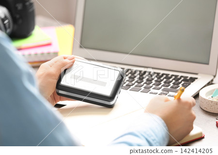 Journalist with voice recorder working at table in office, closeup Journalist with voice recorder working at table in office, closeup 142414205