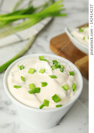 Fresh sour cream with onion on white marble table, closeup Fresh sour cream with onion on white marble table, closeup 142414237