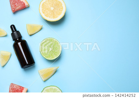 Flat lay composition with citrus essential oil on light blue background. Space for text 142414252