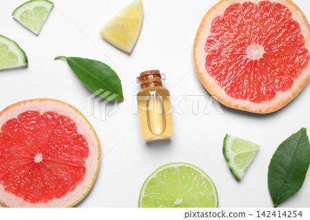 Flat lay composition with bottle of citrus essential oil on white background Flat lay composition with bottle of citrus essential oil on white background 142414254