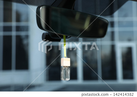 Air freshener hanging on rear view mirror in car Air freshener hanging on rear view mirror in car 142414382
