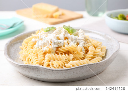 Tasty pasta with sauce and basil on white wooden table, closeup 142414528