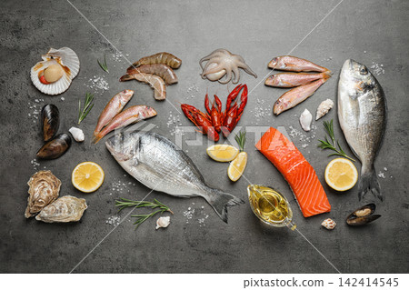 Fresh fish and seafood on grey table, flat lay Fresh fish and seafood on grey table, flat lay 142414545