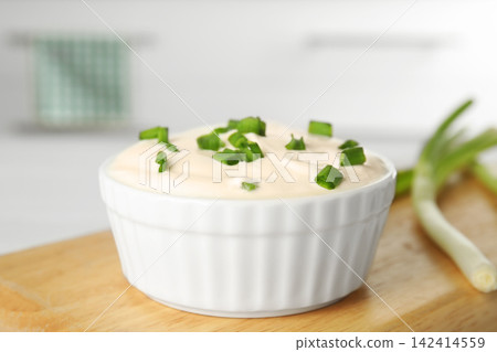 Fresh sour cream with onion on wooden board, closeup Fresh sour cream with onion on wooden board, closeup 142414559