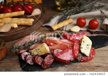 Tasty ham with other delicacies served on wooden table Tasty ham with other delicacies served on wooden table 142414637