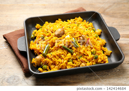 Delicious rice pilaf with vegetables on wooden table Delicious rice pilaf with vegetables on wooden table 142414684