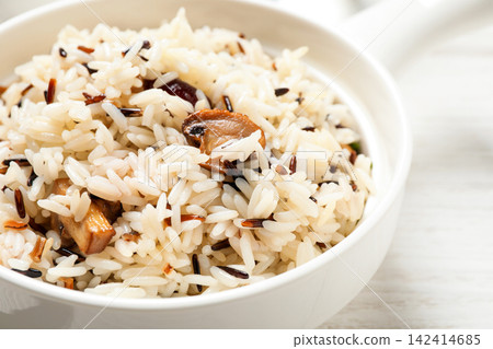 Delicious rice pilaf with mushrooms on white table, closeup Delicious rice pilaf with mushrooms on white table, closeup 142414685