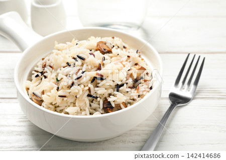 Delicious rice pilaf with mushrooms on white wooden table Delicious rice pilaf with mushrooms on white wooden table 142414686