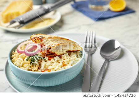 Delicious chicken risotto served in bowl on table Delicious chicken risotto served in bowl on table 142414726